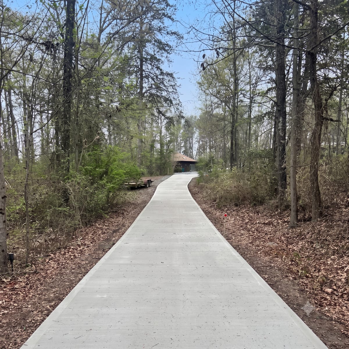 Broom-finish concrete driveway through a wooded lot in Upstate SC