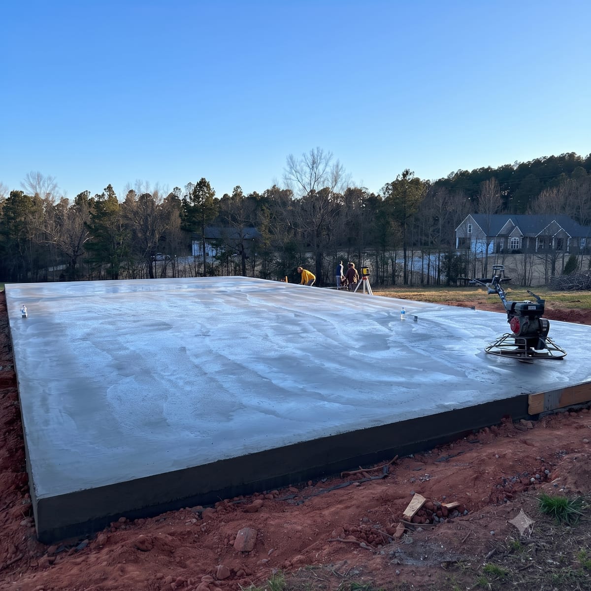 Freshly poured garage slab foundation being power-troweled in Upstate SC