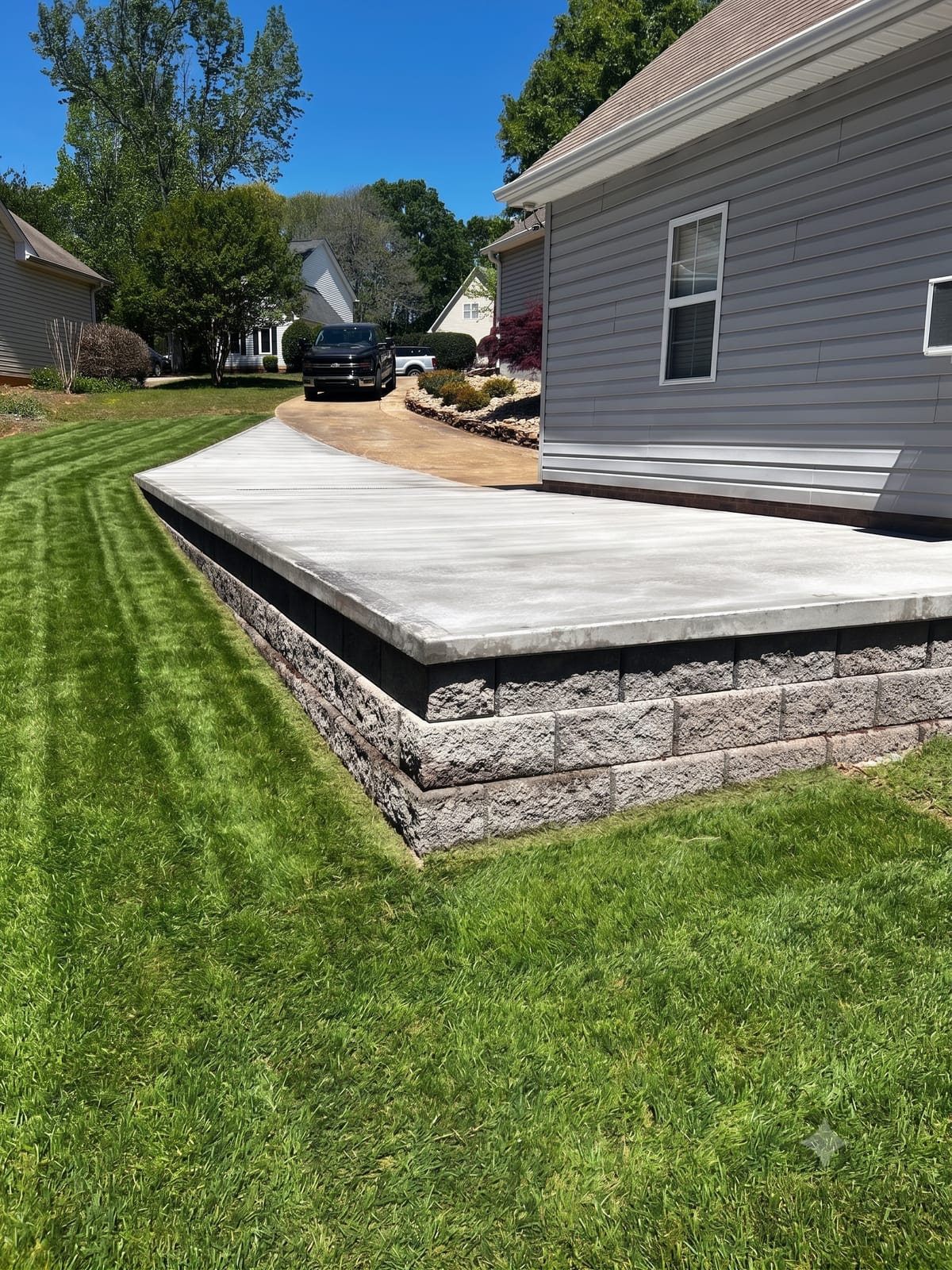 Block retaining wall with poured concrete slab in Upstate SC