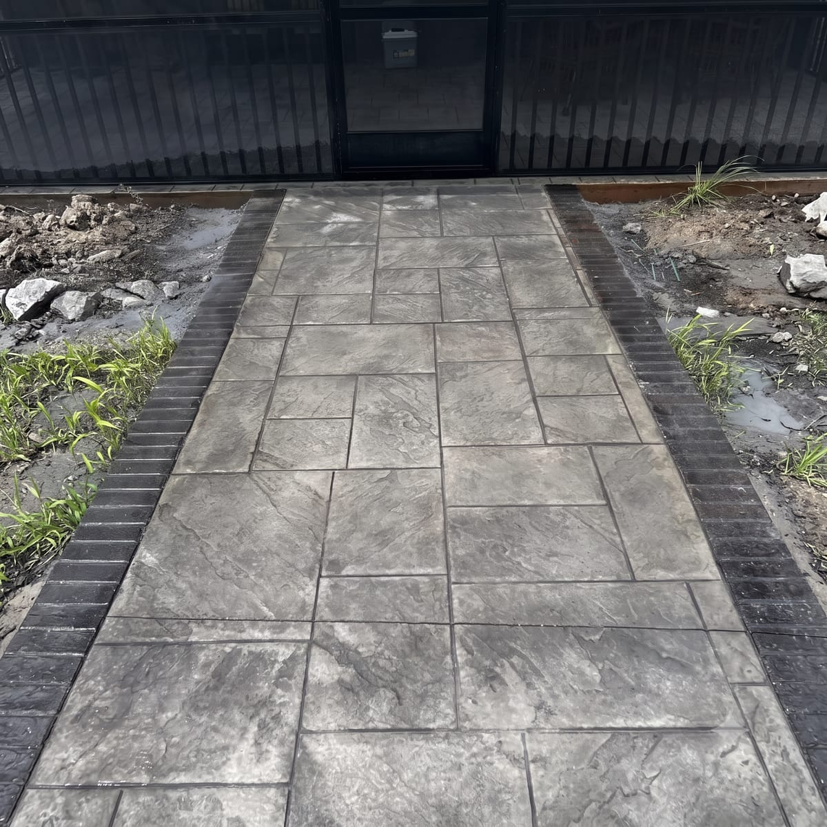 Stamped slate concrete walkway with dark brick border in Upstate SC